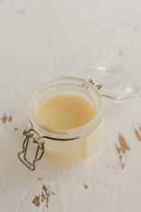 Tasty condensed milk in a jar on a white background.