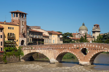 View of the ancient Roman arch Stone Bridge (Ponte Pietra) over the Adige River in Verona, Italy / APRIL 21, 2019