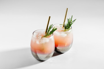 Two glass with Grapefruit and Rosemary cocktail. Summer drinks with fresh citrus and ice.
