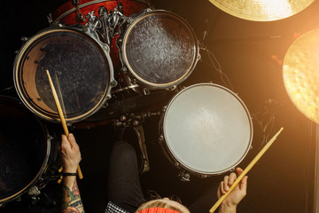professional young drummer play drums in studio, music performer hits the drums with sticks. rock and roll music, instruments concept
