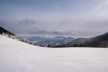 Fototapeta na wymiar Snow covered meadow in the mountains with mountains in the background and a beautiful arch, Slovakia Mala Fatra