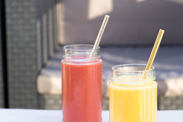 Yellow Banana, pear and red apple, raspberry smoothie. Glass, jar, metal straw. Restaurant, table, armchair. Health, vegetarian, vegan breakfast, drink. No plastic, Ecology. copy space. 