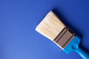 Paint brush on dark blue background, repair concept.