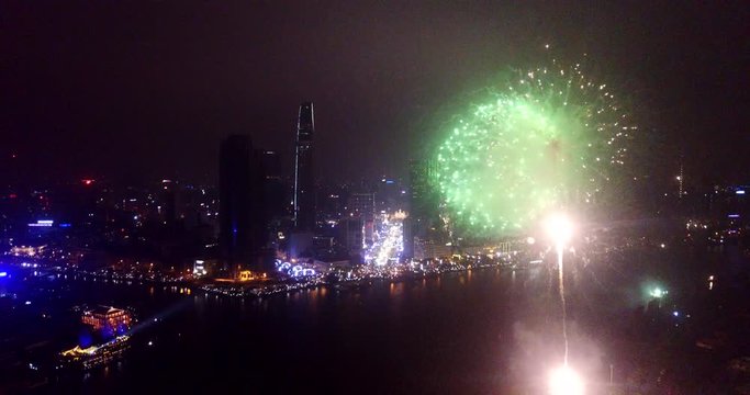 Aerial view of firework with cityscape night light view of river side skyline in new year. The best high-quality free stock footage of night scene with firework celebration. Ho Chi Minh city, Vietnam