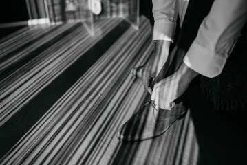 Naklejka premium The businessman is preparing for the job. A man puts on his shoes