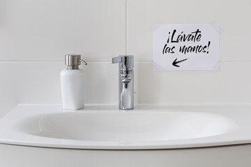 Sink with soap dispenser and note saying 