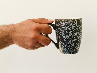 hand holding a cup of coffee with white bacgrounf