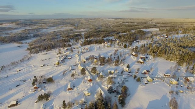 Aerial view of a small village and nature in the north of Sweden during golden hour
