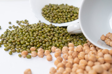 Handfuls of Turkish peas and Green mung bean with white cups on the table. Close-up. Traditional food ingredients