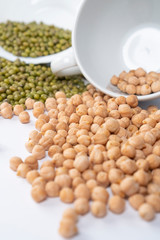 Green mung bean and turkish peas with white cups on the table. Macro shot. Asian ingredients of traditional dishes. Vertical view