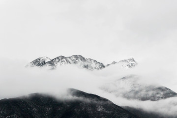 winter landscape of snow mountain peak in fog  - 332244326