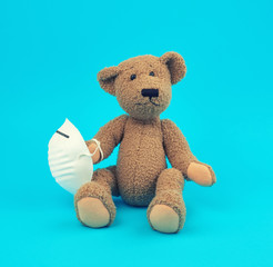 teddy bear are sitting in medical masks on a blue background, concept of protection