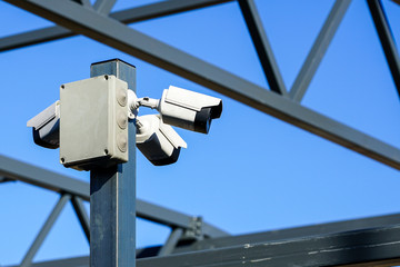 a pillar with three surveillance cameras on the construction site