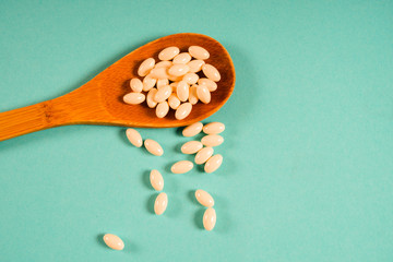 Wooden spoon with a measuring tape on a blue background, diet, healthy lifestyle.