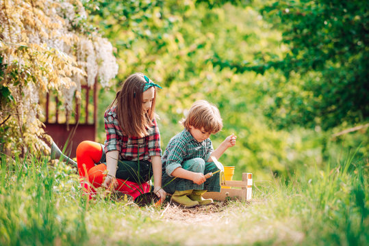 Children And Vegetables On The Farm. Eco Resort Activities. Children Play In Spring Garden. Planting And Flower Growing Concept.