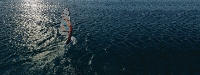Aerial drone ultra wide photo of wind surfer cruising in high speed in tropical exotic bay
