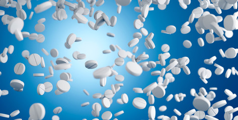Falling pills on blue background