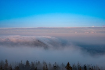 A roll of fog through the mountains into the valley at sunrise and sunset months