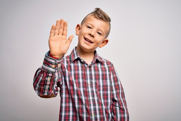 Naklejka premium Young little caucasian kid with blue eyes wearing elegant shirt standing over isolated background Waiving saying hello happy and smiling, friendly welcome gesture