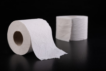 White toilet paper on a dark table. Articles for daily hygiene.