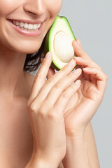 Young beautiful woman holding avocado