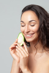 Young beautiful woman holding avocado