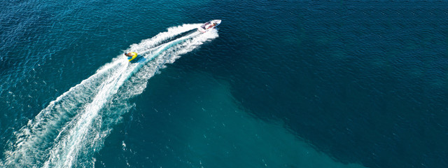 Aerial drone ultra wide photo of water skier cruising in high speed in tropical exotic bay