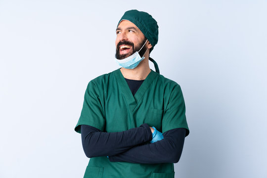 Surgeon man in green uniform over isolated background happy and smiling