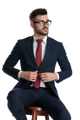 businessman sitting and opening his jacket with style