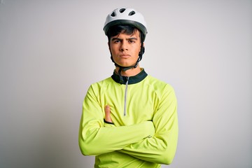 Young handsome cyclist man wearing security bike helmet over isolated white background skeptic and nervous, disapproving expression on face with crossed arms. Negative person.