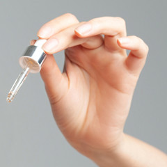 Hands of young woman with a pipette closeup