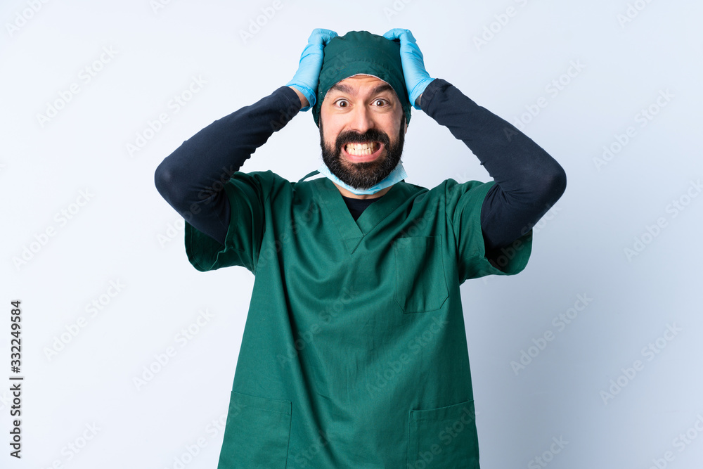 Wall mural Surgeon man in green uniform over isolated background doing nervous gesture