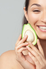 Young beautiful woman holding avocado