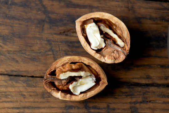 open halves of a fresh raw walnuts on a grunge wooden background. rustic and detailed image. concept.