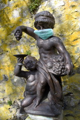 Brunnenfigur mit Gesichtsmaske zum Schutz gegen Corona-Viren