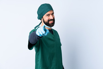 Surgeon man in green uniform over isolated background pointing front with happy expression