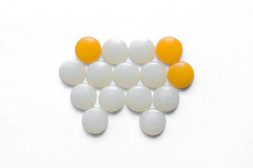 Caries. Pain in the teeth, toothache. Round white and yellow details lie in the shape of a tooth, concept. Harm of sugar. Visit to the dentist. Light background.