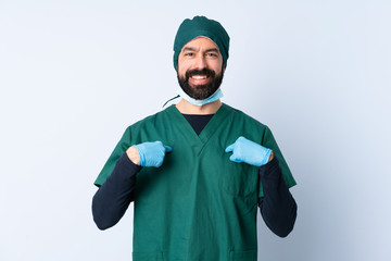 Surgeon man in green uniform over isolated background with surprise facial expression