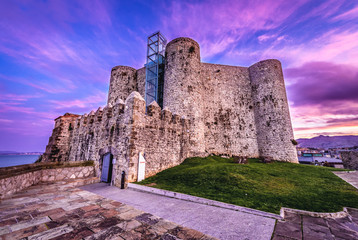 Fototapeta premium Sunset over Saint Anne castle in Castro Urdiales city, Spain