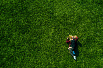 Happy woman relaxing on the grass. Aerial top view of vacation during sunny summer day