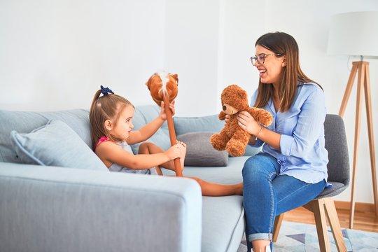 Young Therapist Woman Speaking And Treating Child, Counselor And Behaviour Correction At Pedagogue Payroom Playing With Stuffed Animal