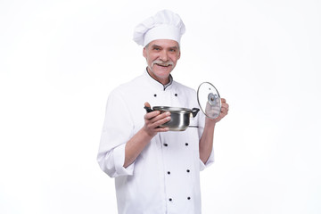 Smiling mature male chef with metal bowl in hands on white background