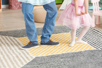 Father and his little daughter dancing at home