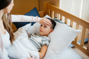 A mother takes care of her child who has a fever and fever. Disease and healthcare