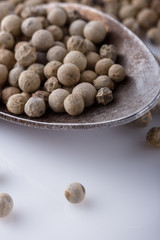 white peppercorns in glass bowl with spoon