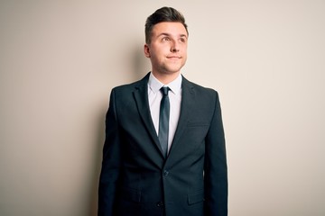 Young handsome business man wearing elegant suit and tie over isolated background smiling looking to the side and staring away thinking.