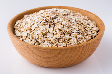 raw oat flakes on white acrylic background