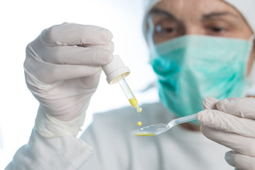 The doctor prepares an oral vaccine with pipette and spoon