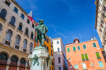 Naklejka premium Carlo Goldoni Monument on Campo Bortolomio square between colorful buildings, blue sky background, Venice city, Veneto Region, Northern Italy