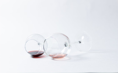 Glasses with red and pink wine laying on white background